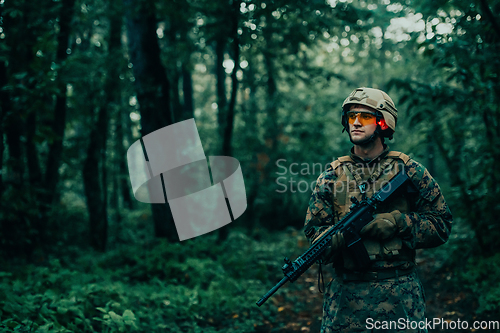 Image of A modern warfare soldier on war duty in dense and dangerous forest areas. Dangerous military rescue operations