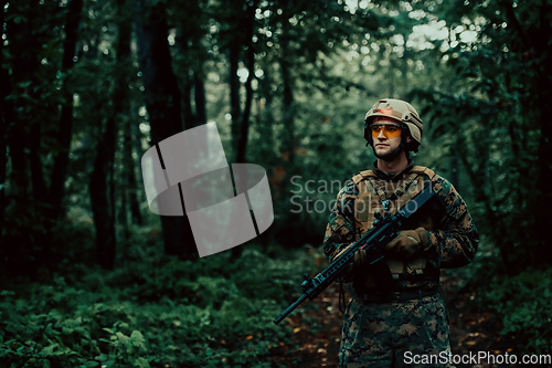 Image of A modern warfare soldier on war duty in dense and dangerous forest areas. Dangerous military rescue operations