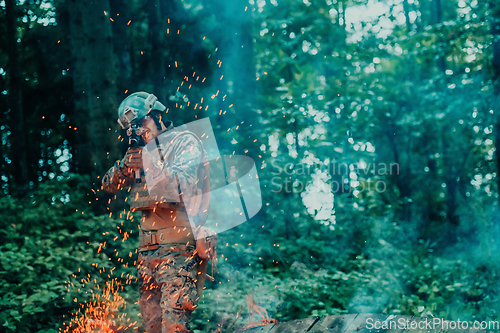 Image of A soldier fights in a warforest area surrounded by fire