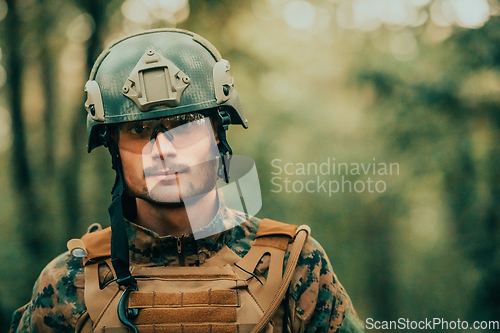 Image of Soldier portrait with protective army tactical gear and weapon having a break and relaxing