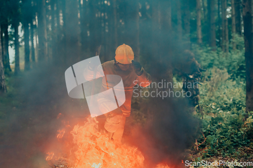 Image of firefighter hero in action danger jumping over fire flame to rescue and save