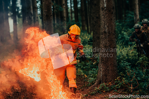 Image of firefighter hero in action danger jumping over fire flame to rescue and save