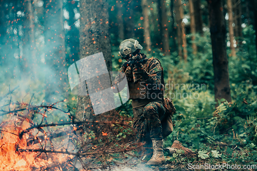 Image of A soldier fights in a warforest area surrounded by fire