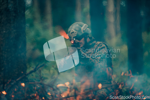 Image of A soldier fights in a warforest area surrounded by fire