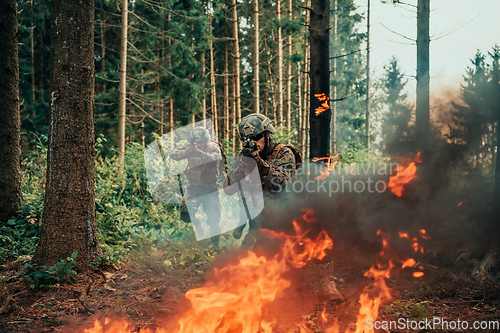 Image of Modern warfare soldiers surrounded by fire fight in dense and dangerous forest areas