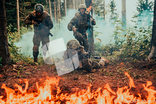 Image of Modern warfare soldiers surrounded by fire fight in dense and dangerous forest areas