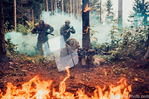 Image of Modern warfare soldiers surrounded by fire fight in dense and dangerous forest areas