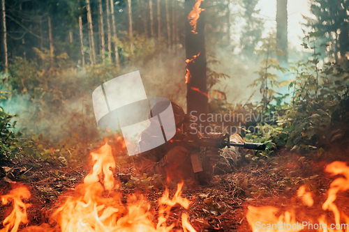 Image of Modern warfare soldier surrounded by fire, fight in dense and dangerous forest areas