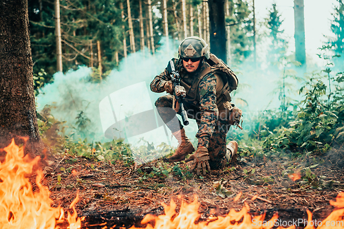 Image of Modern warfare soldier surrounded by fire, fight in dense and dangerous forest areas