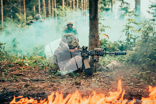 Image of Modern warfare soldiers surrounded by fire fight in dense and dangerous forest areas