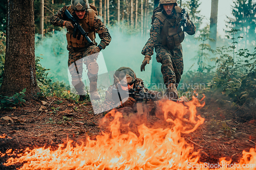 Image of Modern warfare soldiers surrounded by fire fight in dense and dangerous forest areas