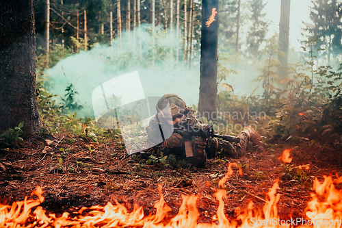 Image of Modern warfare soldier surrounded by fire, fight in dense and dangerous forest areas