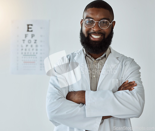 Image of Eye exam, portrait and black man or doctor with arms crossed and glasses with happy service in healthcare. Ophthalmology, face and expert to check vision, test or assessment for eyes or health