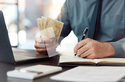 Image of Hands, money and saving with writing, book and accounting for audit, balance and financial review in workplace. Man, pen and notebook with cash, bills and budget for small business, investing or goal