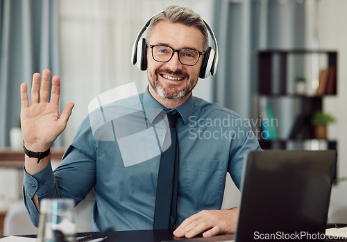 Image of Portrait, headphones and man wave on video call for business smile in online chat at home. Happy face, hello and webinar of mature manager with glasses in virtual meeting for remote work on laptop