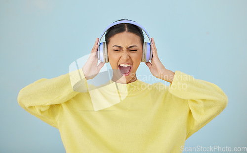 Image of Music, shouting and headphones with a woman in studio on a gray background while streaming audio. Radio, screaming or expression and a young person listening to sound or noise with her eyes closed