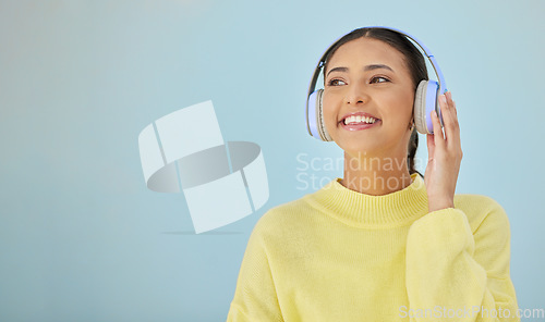 Image of Happy woman, headphones and banner mockup in studio listening to podcast, app and streaming radio site. Smile, music media subscription and sound, face of girl with audio on blue background space.