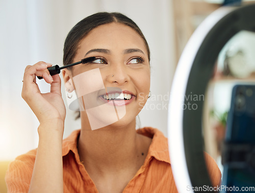 Image of Smile, house and a woman with makeup and a phone for influencer review, social media or blog. Thinking, happy and a young girl with mascara or cosmetics and mobile lighting for live streaming vlog