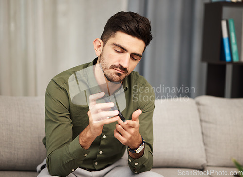 Image of Man, diabetes and blood sugar check with pen for healthcare and insulin monitor at home. Male person, medical test and glucose analysis in a living room with medicine, care and clinic tool in a house