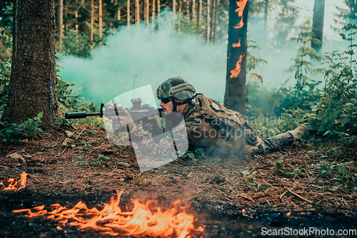 Image of Modern warfare soldier surrounded by fire, fight in dense and dangerous forest areas