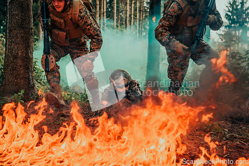 Image of Modern warfare soldiers surrounded by fire fight in dense and dangerous forest areas