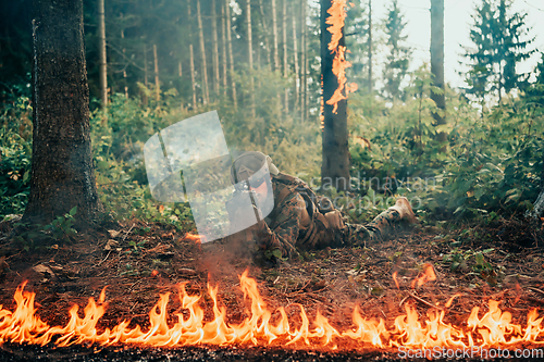 Image of Modern warfare soldier surrounded by fire, fight in dense and dangerous forest areas