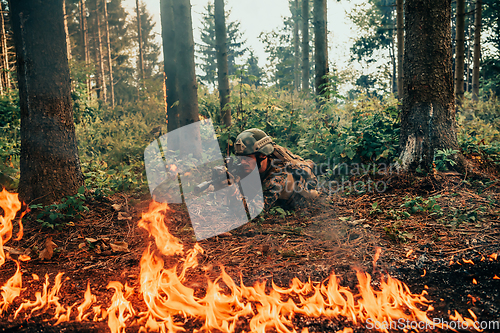 Image of Modern warfare soldier surrounded by fire, fight in dense and dangerous forest areas