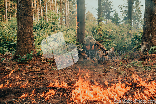 Image of Modern warfare soldier surrounded by fire, fight in dense and dangerous forest areas