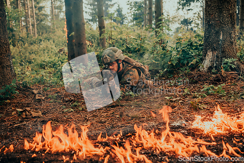 Image of Modern warfare soldier surrounded by fire, fight in dense and dangerous forest areas