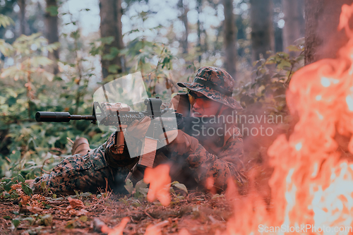 Image of A soldier fights in a warforest area surrounded by fire