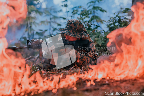 Image of A soldier fights in a warforest area surrounded by fire