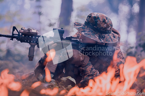 Image of A soldier fights in a warforest area surrounded by fire