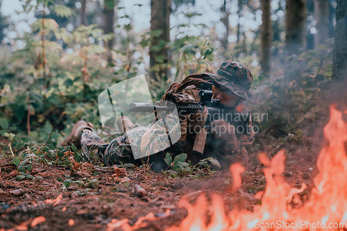 Image of A soldier fights in a warforest area surrounded by fire