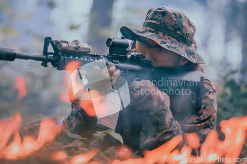 Image of A soldier fights in a warforest area surrounded by fire