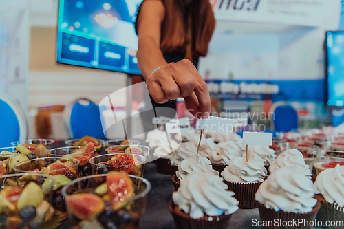 Image of Business woman takes delicious food from the table while in the conference room