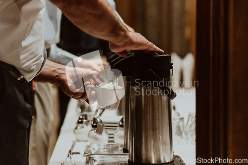 Image of The waiter preparing coffee for hotel guests. Close up photo of service in modern hotels