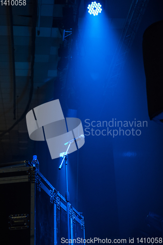 Image of microphone in concert hall with blue lights
