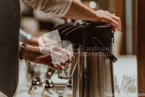 Image of The waiter preparing coffee for hotel guests. Close up photo of service in modern hotels