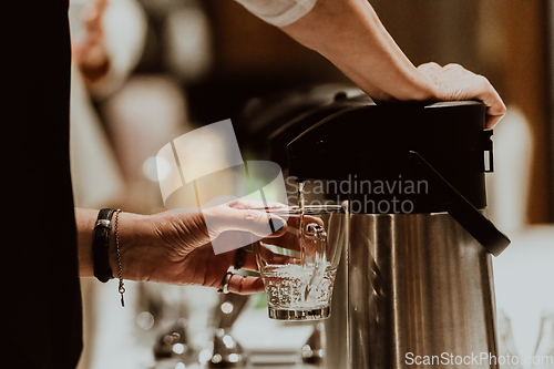 Image of The waiter preparing coffee for hotel guests. Close up photo of service in modern hotels