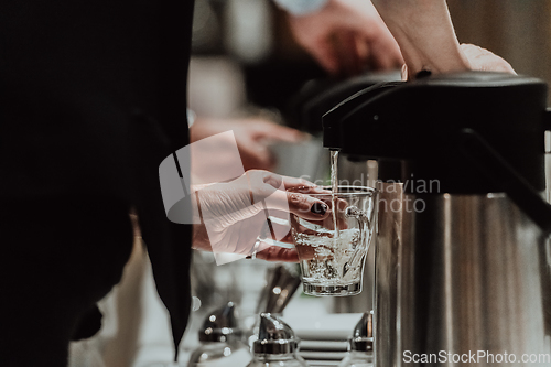 Image of The waiter preparing coffee for hotel guests. Close up photo of service in modern hotels