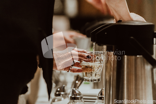 Image of The waiter preparing coffee for hotel guests. Close up photo of service in modern hotels