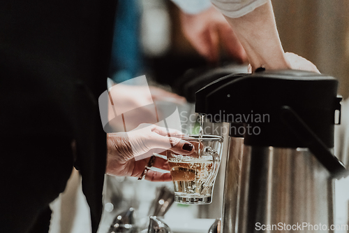 Image of The waiter preparing coffee for hotel guests. Close up photo of service in modern hotels