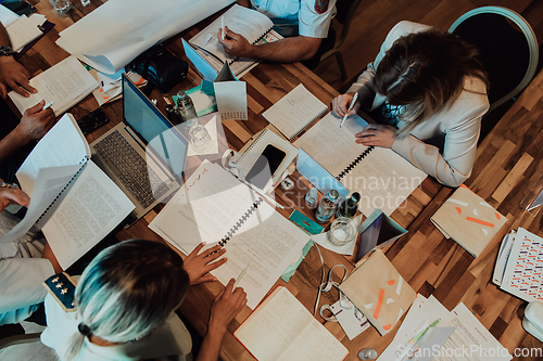 Image of Top view of colleagues sorting out paperwork together. Businessman working with documentation