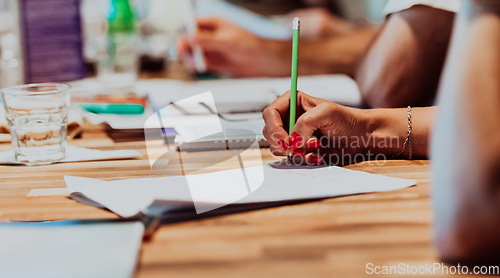 Image of Closeup shot of business people hands using pen while taking notes on education training during business seminar at modern conference room