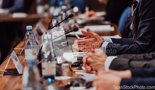 Image of Closeup shot of business people hands using pen while taking notes on education training during business seminar at modern conference room