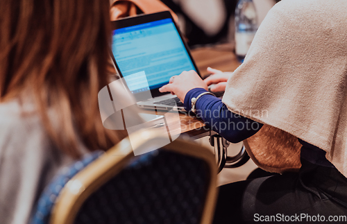 Image of Close up photo of a woman's hand using on a laptop at a seminar