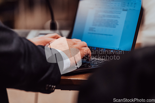 Image of Close up photo of a businessman typing on a laptop