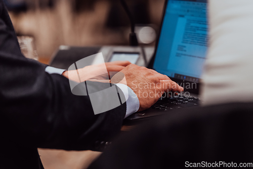 Image of Close up photo of a businessman typing on a laptop