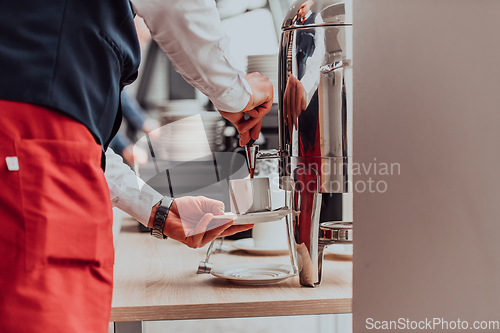 Image of The waiter preparing coffee for hotel guests. Close up photo of service in modern hotels