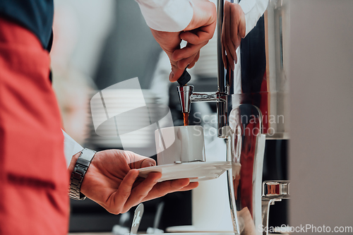 Image of The waiter preparing coffee for hotel guests. Close up photo of service in modern hotels